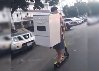 Homem é filmado transportando fogão nas costas em patinete elétrico. Foto: Reprodução de Internet