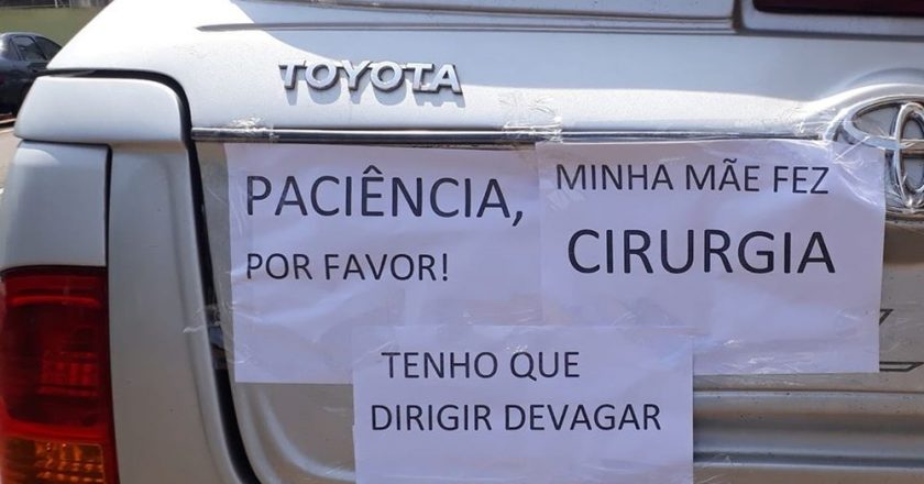 Mulher coloca cartazes em carro para justificar lentidão em viagem. Foto: Reprodução de Internet