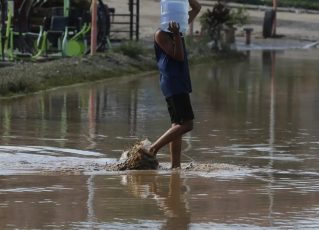 Pessoa enfrente água após chuvas no Rio. Foto: Fernando Frazão/Agência Brasil
