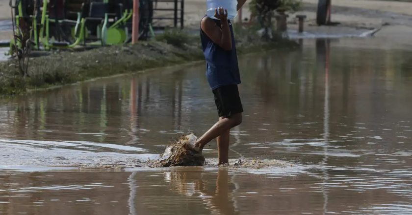Pessoa enfrente água após chuvas no Rio. Foto: Fernando Frazão/Agência Brasil